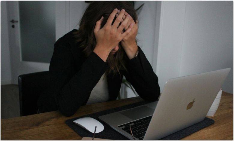 Frustrated woman in front of laptop.