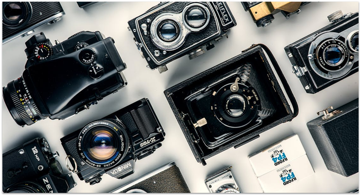 Analog film cameras laid out on a white table